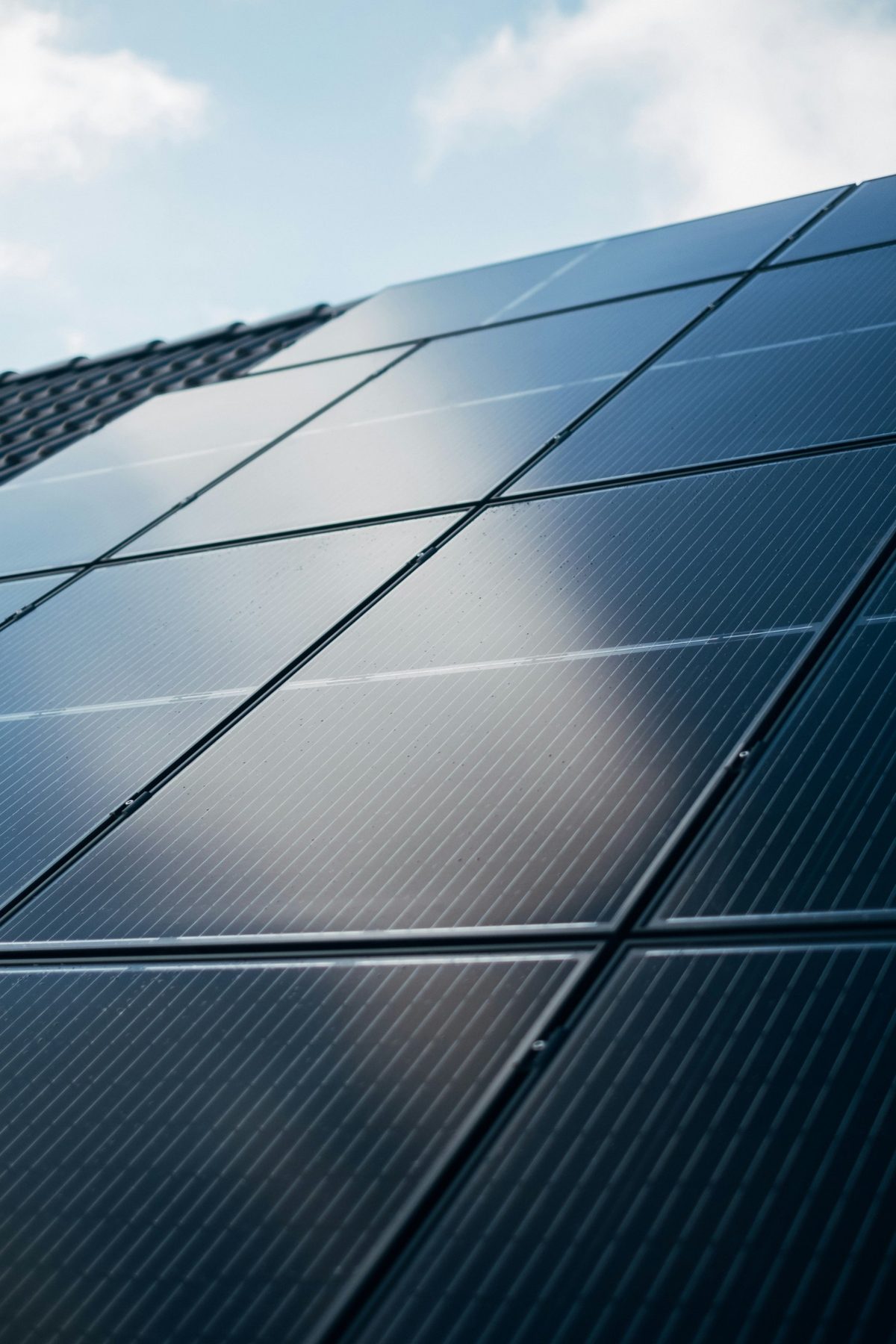 Close-up of dark solar panels reflecting the sky